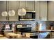 Stylish kitchen showcasing modern appliances, gray cabinetry, decorative backsplash, and beautiful globe pendant lighting at 2806 W Shelton Ave, Tampa, FL 33611