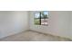 Bright bedroom featuring wood-look flooring and natural light from a window with an exterior view of a house at 18213 Cresswind Ter, Lakewood Ranch, FL 34211