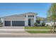 A modern, light gray, single-story home with a three-car garage and manicured landscaping under a clear, blue sky at 18213 Cresswind Ter, Lakewood Ranch, FL 34211