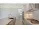 A modern kitchen showcasing stainless steel appliances, white cabinets, quartz countertops, and a gas cooktop at 18213 Cresswind Ter, Lakewood Ranch, FL 34211