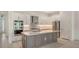 A modern kitchen featuring stainless steel appliances, gray lower cabinets, white upper cabinets, and a central island at 18213 Cresswind Ter, Lakewood Ranch, FL 34211