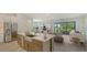 Bright open-concept kitchen with stainless steel appliances and a large island, flowing into the living area at 18213 Cresswind Ter, Lakewood Ranch, FL 34211