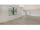 Spacious room featuring wood flooring, a large window overlooking the yard, and sliding glass doors at 18213 Cresswind Ter, Lakewood Ranch, FL 34211
