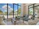Stylish living room with floor-to-ceiling windows offering stunning views of the community pool and palm trees at 18213 Cresswind Ter, Lakewood Ranch, FL 34211