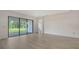 Spacious living room with wood floors, a sliding glass door, and ample natural light at 18213 Cresswind Ter, Lakewood Ranch, FL 34211