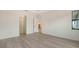 Spacious main bedroom with wood-look flooring, a tray ceiling, natural light, and doorway to bathroom and closet at 18213 Cresswind Ter, Lakewood Ranch, FL 34211