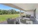 Covered patio area with comfortable seating overlooking a green lawn and backyard at 18213 Cresswind Ter, Lakewood Ranch, FL 34211