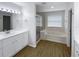 Bathroom features a double sink vanity, bathtub, and a glass door shower at 2007 Rain Dance Pl, Brandon, FL 33510