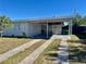 Exterior view of the home with an attached carport and well-maintained front yard with nice landscaping at 681 Dalton Blvd, Port Charlotte, FL 33952