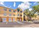 Sunny condo building featuring private garages, stairs to upper units, and lush palm trees at 10764 70Th Ave # 3305, Seminole, FL 33772
