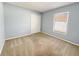 Bedroom with light blue walls, carpeted floors, window and a closet at 12092 Rockford St, Spring Hill, FL 34608