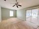Large bedroom with a ceiling fan, carpet, and sliding glass doors leading to an enclosed porch at 12092 Rockford St, Spring Hill, FL 34608