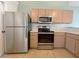 Kitchen with stainless steel appliances and light wood cabinetry, ideal for culinary enthusiasts at 12092 Rockford St, Spring Hill, FL 34608