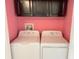 Laundry room with a washer and dryer with pink walls at 12092 Rockford St, Spring Hill, FL 34608