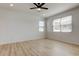 Bright bedroom with a ceiling fan, wood laminate flooring, and two windows at 25242 Carnation Sedge Way, Land O Lakes, FL 34639