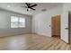 A bedroom with a ceiling fan, and wood laminate flooring, two doors, and a window at 25242 Carnation Sedge Way, Land O Lakes, FL 34639