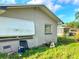Exterior home with an enclosed patio, storage area, chair and lawn at 1420 Citrus St, Clearwater, FL 33756