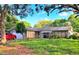 Charming single-story home featuring a well-kept lawn and vibrant landscaping, enhanced by mature trees and sunny skies at 1420 Citrus St, Clearwater, FL 33756