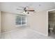 Light-filled bedroom features a ceiling fan and view to an ensuite bathroom at 7708 Belah Dr, New Port Richey, FL 34653
