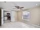 Well-lit bedroom has a ceiling fan and large window with a glimpse of the kitchen at 7708 Belah Dr, New Port Richey, FL 34653