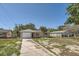 Charming single-story home with a driveway, attached garage, and a red front door at 7708 Belah Dr, New Port Richey, FL 34653