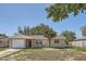 Cozy single-story home with a driveway, attached garage, and a red front door at 7708 Belah Dr, New Port Richey, FL 34653