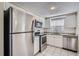 Well-lit kitchen featuring stainless steel appliances and white cabinetry, offering a clean, modern feel at 7708 Belah Dr, New Port Richey, FL 34653