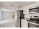 Spacious kitchen boasts modern appliances, granite counters, and flows into a bright, tiled living area at 7708 Belah Dr, New Port Richey, FL 34653