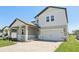 Charming two-story home with covered porch, brick accents, manicured lawn, and an attached two car garage at 1878 Draughton Dr, Zephyrhills, FL 33541