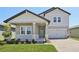 Charming front exterior featuring stone accents, light gray siding, and a covered porch at 1878 Draughton Dr, Zephyrhills, FL 33541
