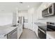 Bright kitchen featuring white cabinets, stainless steel appliances, granite countertops, and wood look tile flooring at 1878 Draughton Dr, Zephyrhills, FL 33541