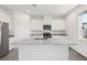 Kitchen featuring white cabinets, stainless steel appliances, granite countertops, a kitchen island and wood look tile flooring at 1878 Draughton Dr, Zephyrhills, FL 33541