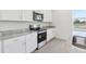 Kitchen featuring white cabinets, stainless steel appliances, granite countertops, and a view of a serene pond at 1878 Draughton Dr, Zephyrhills, FL 33541