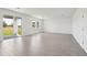 Large living room featuring light gray wood-look tile flooring, sliding glass door, and ample natural light at 1878 Draughton Dr, Zephyrhills, FL 33541