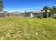 Large backyard with lush green grass, a wooden fence, a storage shed, and ample space for outdoor activities at 3213 Bigelow Dr, Holiday, FL 34691