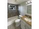 Cozy bathroom with tiled walls, granite countertop, single sink vanity, and a bathtub and shower combo at 3213 Bigelow Dr, Holiday, FL 34691