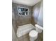 Bathroom features a tub with a shower, and a toilet at 3213 Bigelow Dr, Holiday, FL 34691