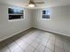 Bright bedroom features tile floors, a ceiling fan, and two windows at 3213 Bigelow Dr, Holiday, FL 34691