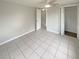 Empty bedroom featuring tile floors, neutral tones, closet space, and ample natural light at 3213 Bigelow Dr, Holiday, FL 34691