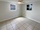 Empty bedroom featuring neutral tones, windows providing natural light, and tile floors at 3213 Bigelow Dr, Holiday, FL 34691