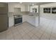 Well-lit kitchen featuring stainless steel appliances, white cabinetry, and tile flooring at 3213 Bigelow Dr, Holiday, FL 34691