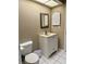 A clean bathroom features a white vanity and toilet with tiled flooring at 3652 Oak Grove Dr, Sarasota, FL 34243