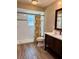 Bright bathroom featuring a shower, wood-look flooring and a dark wood vanity at 3652 Oak Grove Dr, Sarasota, FL 34243