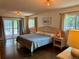 Bright bedroom featuring a woven headboard, neutral walls, and warm lighting at 3652 Oak Grove Dr, Sarasota, FL 34243