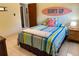 This bedroom features tiled flooring, a surfboard decoration, and a colorful bedspread at 3652 Oak Grove Dr, Sarasota, FL 34243