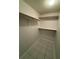 Walk-in closet with white shelves and tiled flooring at 3652 Oak Grove Dr, Sarasota, FL 34243
