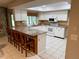 Bright kitchen with granite countertops, white cabinetry, and an island with bar seating at 3652 Oak Grove Dr, Sarasota, FL 34243