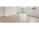 Spacious living room with light wood-look flooring and sliding glass doors to the backyard at 2320 E Newsome Rd, Plant City, FL 33565