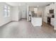 Spacious living room with light wood-look flooring open to the kitchen with white cabinets at 2320 E Newsome Rd, Plant City, FL 33565