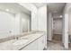 Bright bathroom featuring a double vanity with granite countertop and framed mirror at 3904 Radiant Mountain Dr, Plant City, FL 33565